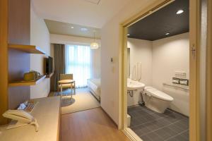 那霸Hotel Resol Trinity Naha的客房内设有带水槽和卫生间的浴室
