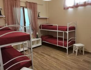 蒙蒂菲阿斯科尼Al Centesimo Chilometro - Ristoro del Pellegrino的一间客房配有三张双层床和红色床单。