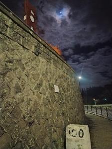 蒙蒂菲阿斯科尼Al Centesimo Chilometro - Ristoro del Pellegrino的石墙,带钟楼