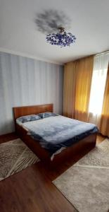 奇姆肯特Центр Чимкент Двушка的一间卧室配有一张带蓝色棉被的床