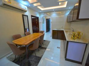 Sīdī Ḩamzahالمسافر 7的厨房配有木桌和一些椅子