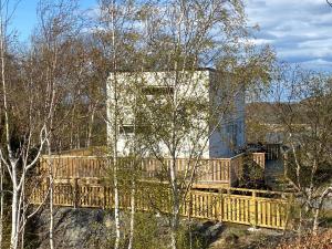 BrännöMycket trevlig stuga på Brännö med havsutsikt的树林中一座木桥的房子