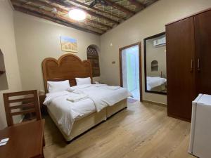 尼兹瓦Nizwa Heritage Inn的一间卧室配有一张大床和镜子