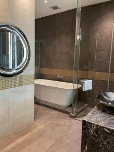 香港嘉富海景酒店的带浴缸、水槽和镜子的浴室