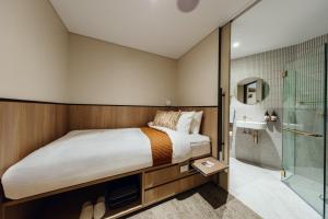 悉尼Aerotel Sydney (Arrivals B, International Terminal 1)的一间卧室设有一张大床和淋浴