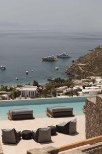 萨鲁Calma Suites Mykonos的享有大海和船只景致的游泳池