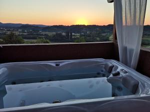 萨格勒布Apartment Viksa with Jacuzzi的浴缸位于阳台,享有日落美景。