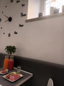 奇维塔韦基亚波尔图迪罗马酒店的墙上挂着一盘食物和钟的桌子