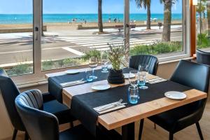 萨洛4R Casablanca Playa的一间设有桌子并享有海滩美景的用餐室