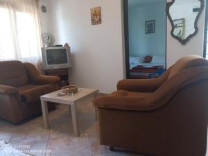 克拉西奇Balkanska 22, Apartment的客厅配有两把椅子、一台电视和一张桌子