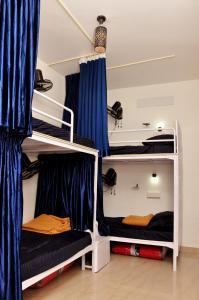 古鲁瓦尤尔Fresh Up In Guruvayur Krishnendhu Residency的配有蓝色窗帘的客房内的两张双层床