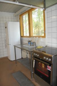 Lemi库哈森萨利度假屋的厨房配有桌子、水槽和冰箱