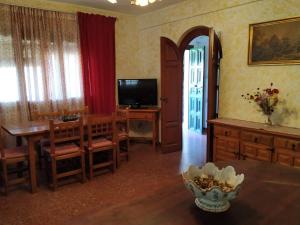 埃尔博斯克Alojamiento Rural Manantial de los Cañitos的客厅设有餐桌和电视