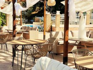 里亚帕德斯Avra Sunset Sea View Liapades的一个带桌椅和遮阳伞的户外庭院。