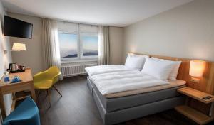 卢塞恩贝尔维尤克林斯酒店的配有一张床、一张书桌和一扇窗户的酒店客房