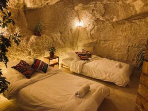 Al Jāyah7 Caves Hotel的洞穴内带两张床的房间