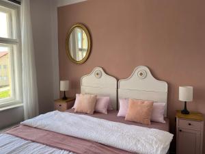 HartmaniceApartment Stará Pošta的一间卧室配有一张带粉红色枕头和镜子的床