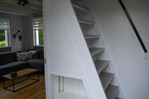 霍勒姆Naar de kust的通往带沙发的客厅的楼梯