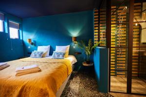 德文格洛Boutique Hotel de Drentse Liefde的一间卧室配有一张带蓝色墙壁的大床