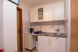 克尔克Apartments City Center Dekanić的厨房配有白色橱柜和水槽