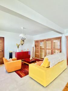卡诺格布拉达Villa Paririö的一间卧室配有黄色的床和沙发