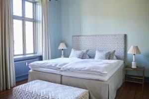 哥本哈根Rye115 Hotel的一间卧室设有一张大床和两个窗户。
