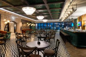 迪拜Premier Inn Dubai Barsha Heights的一间带桌椅的餐厅和一间酒吧