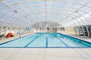 苏斯通Camping Nature L'Airial的一个带玻璃天花板的大型室内游泳池