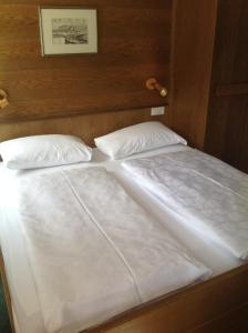 圣马蒂诺-因巴迪亚加尼派恩塔旅馆的一张带两张白色床单和枕头的床