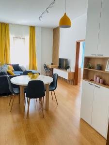 瓦尔纳Уютен апартамент в сърцето на прекрасен град Варна的厨房以及带桌椅的起居室。