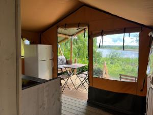 Blankensee'Glamping' Angelzelt am See mit Steg und Boot (Mecklenburger Seenplatte)的帐篷内配备了冰箱和桌子