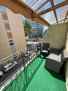 科隆自由科隆酒店的阳台,带两把椅子和一辆车的建筑
