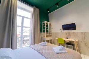 那不勒斯P.C. Boutique H. De Gasperi, Napoli Centro, by ClaPa Group的一间卧室配有一张床、一张书桌和一个窗户。