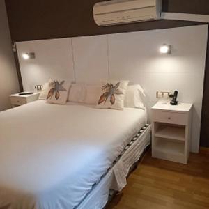 哈卡爱乐奥赛博酒店的卧室配有一张白色的大床和床头柜。
