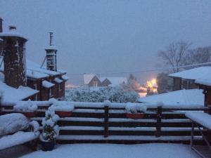 SkelmorlieThe Coach House的雪覆盖的院子,围着栅栏