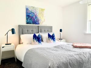 东基尔布赖德Waverley的卧室配有带蓝色枕头的大型白色床