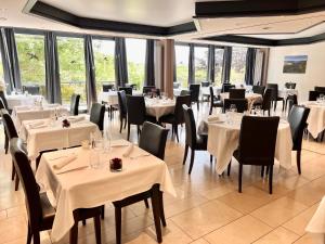 特鲁瓦维耶日Hôtel Restaurant Lamy的餐厅设有白色的桌椅和窗户。
