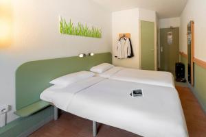图卢兹B&B HOTEL Toulouse Cité de l'Espace Hurel的绿色和白色的房间里一张床位