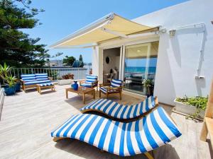 卡利亚里伊尔普罗富莫德尔马酒店的露台配有蓝白色椅子和遮阳伞