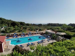 阿尔库季岛布拉提-阿考迪酒店的享有带椅子和遮阳伞的度假村游泳池的空中景致