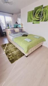 布拉格机场附近巴斯蒂安公寓的一间卧室配有一张带绿色棉被的床