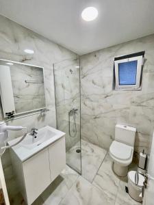 萨兰达Relax Mea Hotel的浴室配有卫生间、盥洗盆和淋浴。