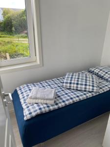 SætraFeriehus med Sjøutsikt的窗户旁的一张带两个枕头的床