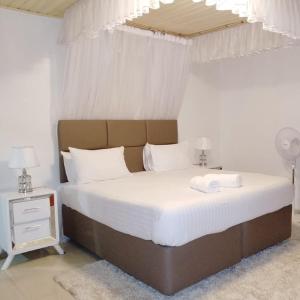 基苏木Sofitel Executive 3 bedrooms milimani的一间卧室配有一张带白色床单的大床