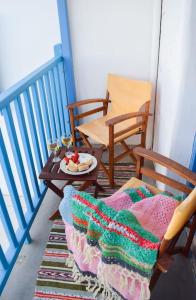 MárpissaΤο πάνω σπίτι της Μαριάνθης的阳台配有两把椅子和一张带一盘食物的桌子。