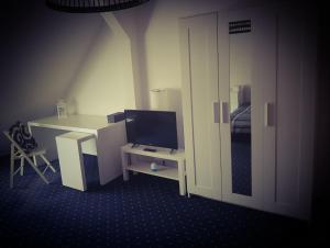 罗斯托克6 bedroom Private APARTMENT & Lounge的客房设有带电脑和电视的书桌。