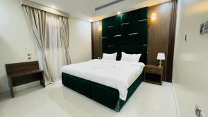 延布فندق فخر ينبع 5的一间卧室配有一张大床和绿色床头板
