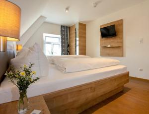 苏尔茨巴赫-罗森贝格Hotelgasthof Bayerischer Hof的卧室配有一张大床,墙上配有电视