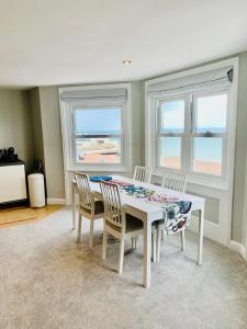 沃辛Stunning Beachfront Apartment, Perfect Sea View.的一间带桌椅和窗户的用餐室