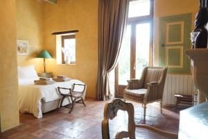 LapaludMaison en Provence的卧室配有一张床和一张桌子及椅子
